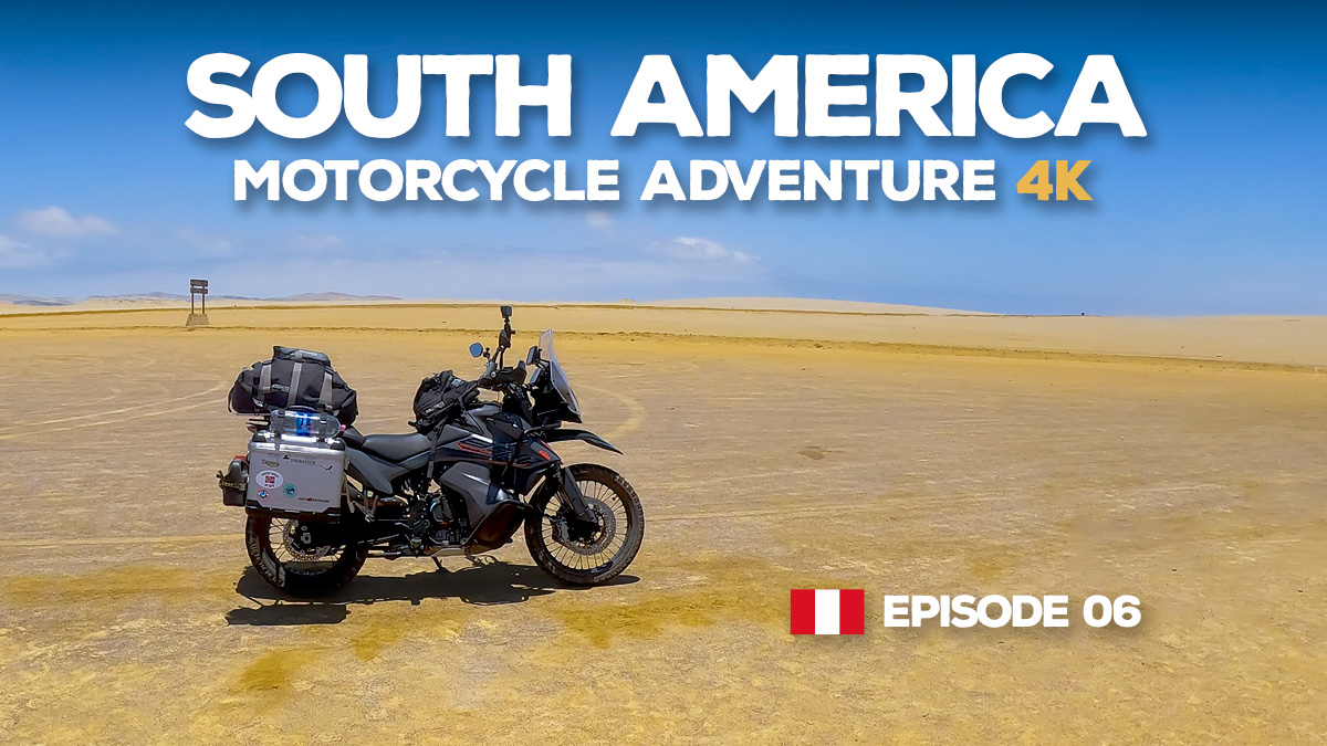 A KTM 890 Adventure motorcycle parked in the yellow desert of Península de Paracas, Peru