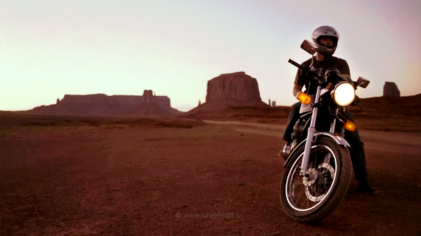 Sunset shot of man on a motorcycle in Monument Valley, USA